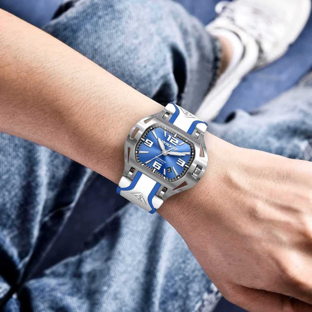 Blue and silver watch on a person's wrist with a blurred background